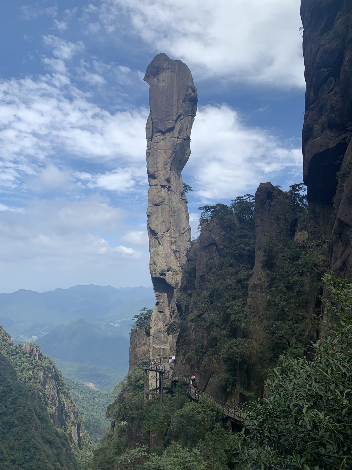 A rock pinnacle rising above forested mountains