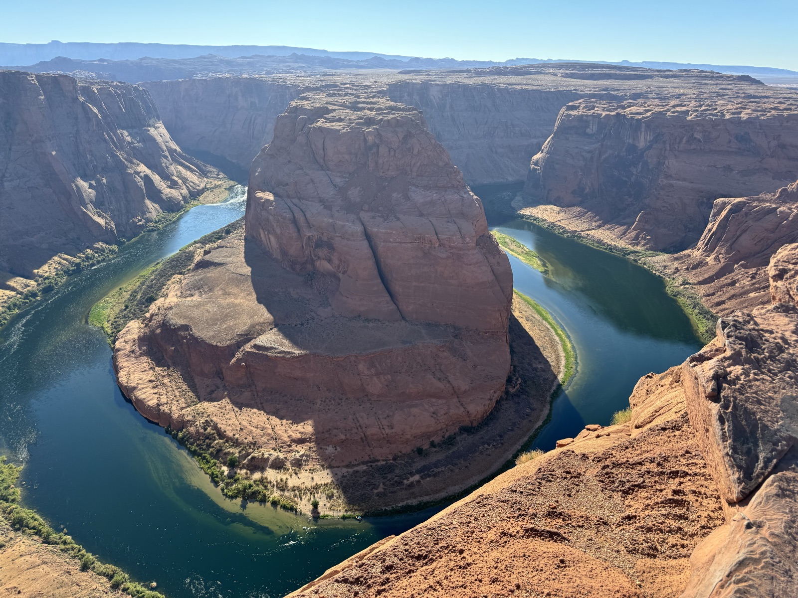 A river looping around a sandstone butte seen from the rim