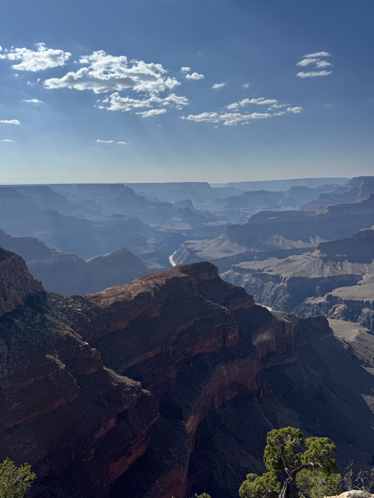 Layered canyon walls receding into haze with a river below
