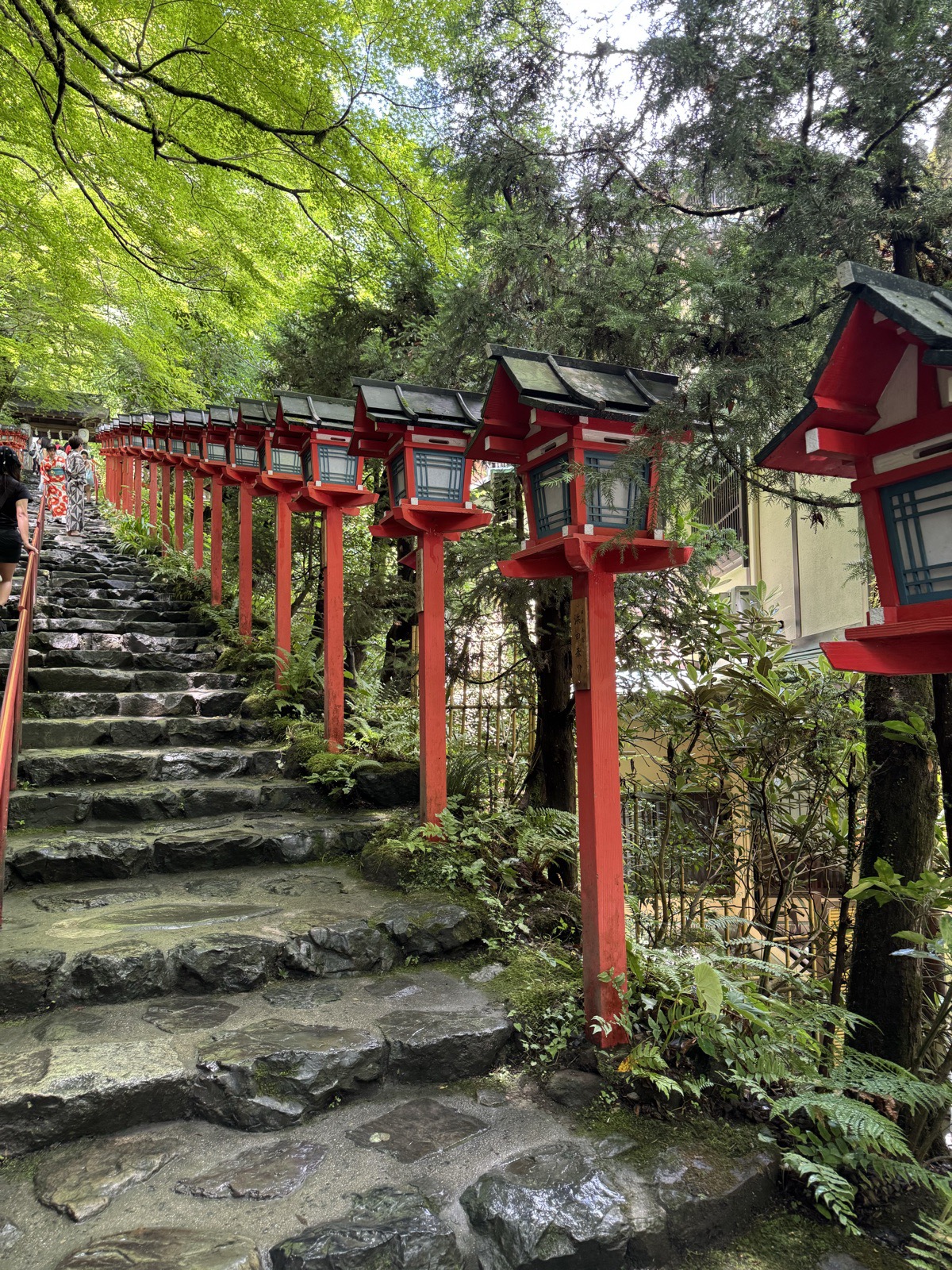 Red lanterns lining a stone stairway to a shrine