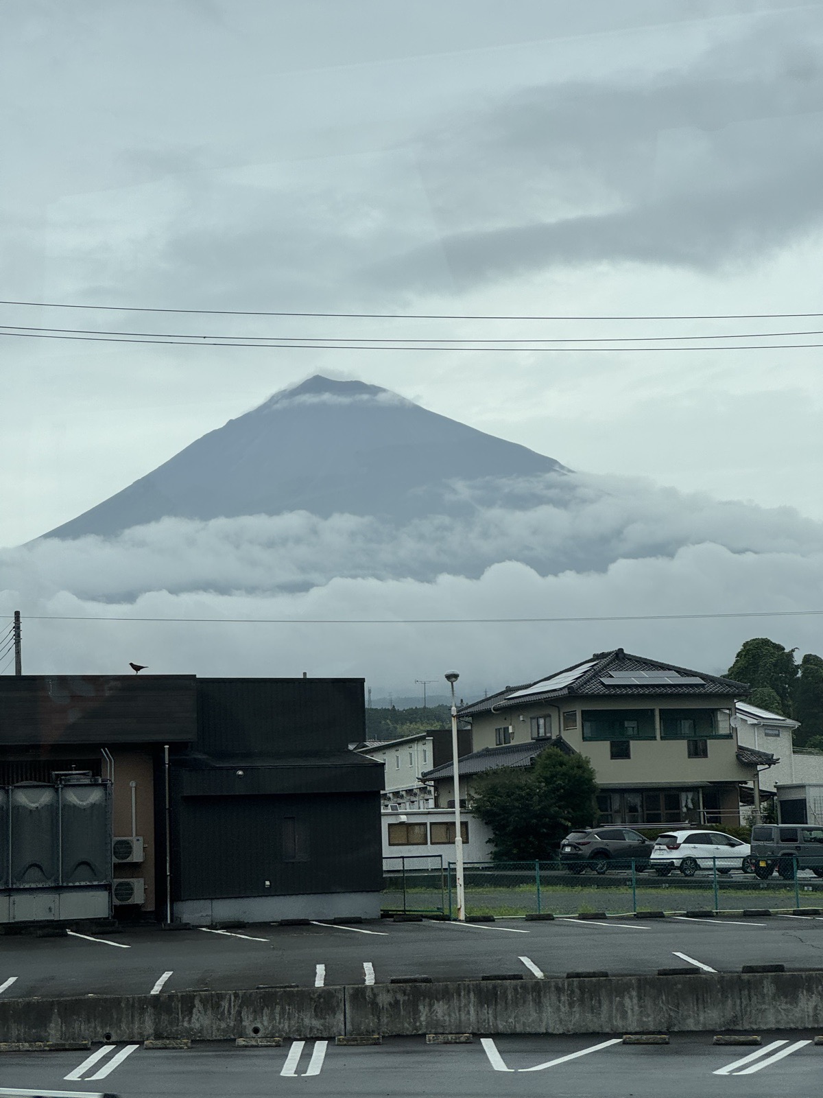 A volcanic cone rising above a band of cloud